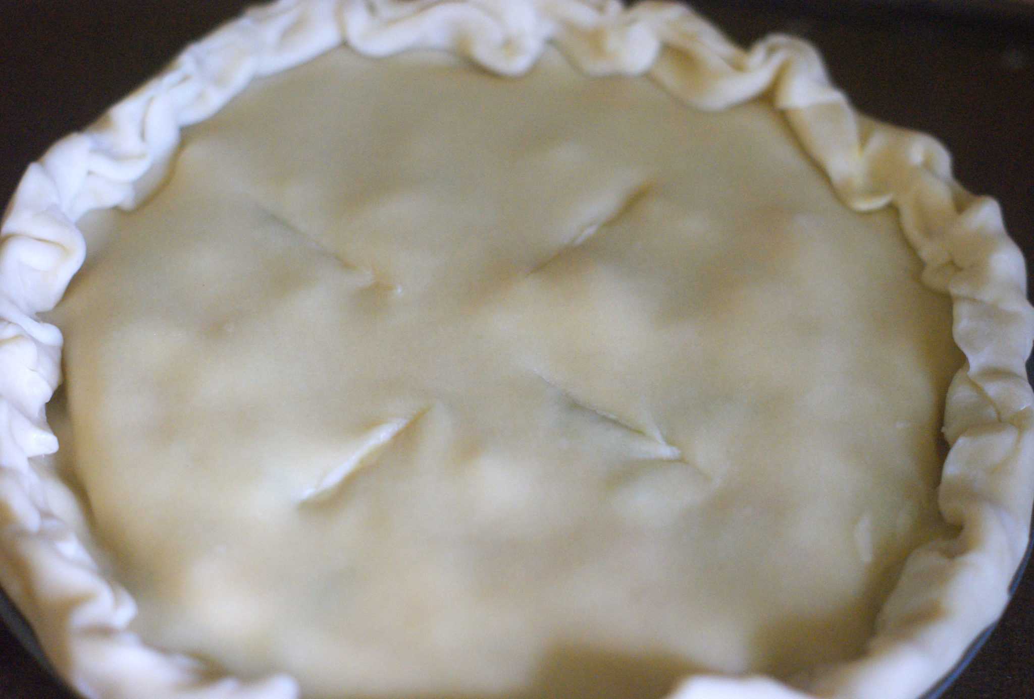 Uncooked chicken pot pie with pie crust