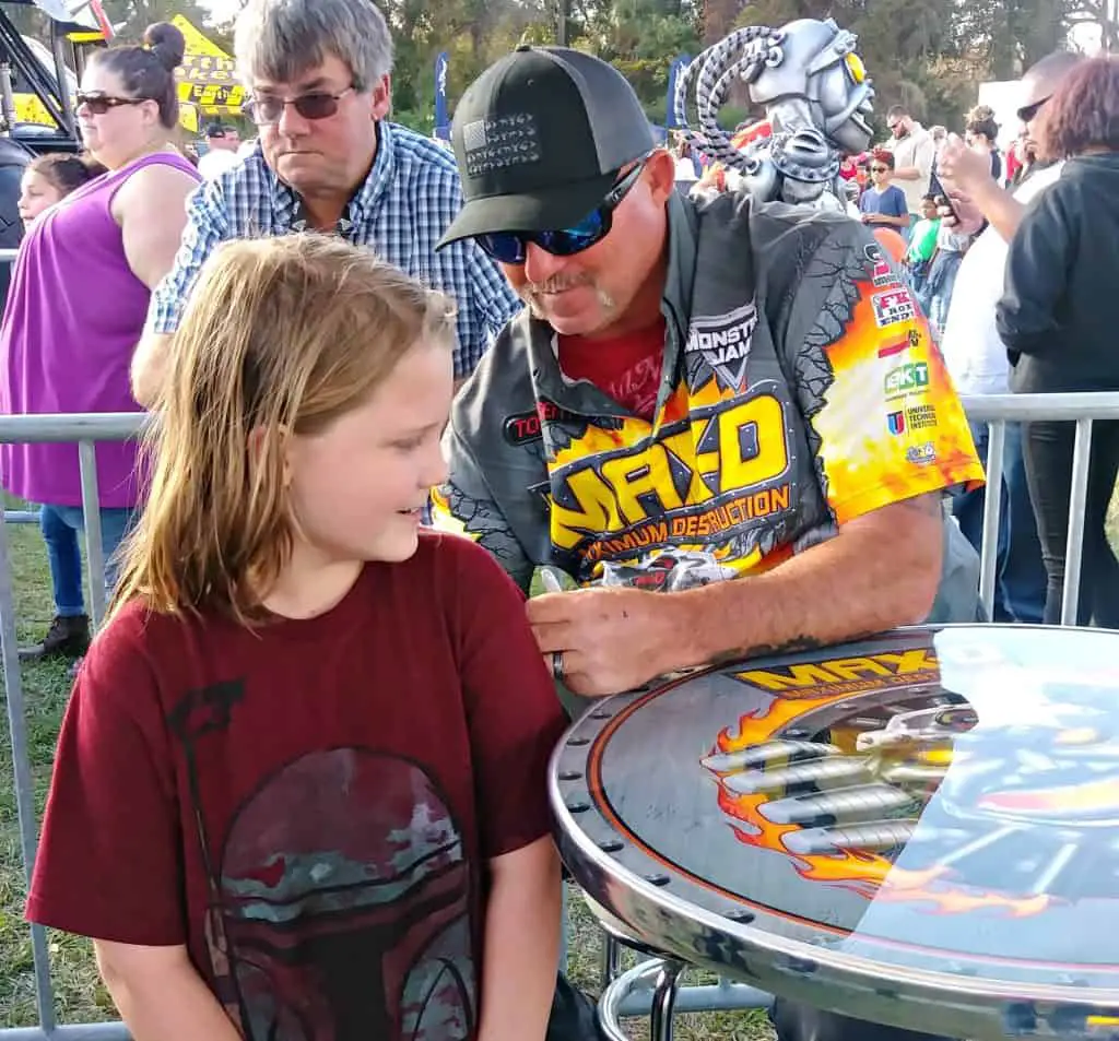 Max D Monster Truck Driver autographing a shirt at the pit party